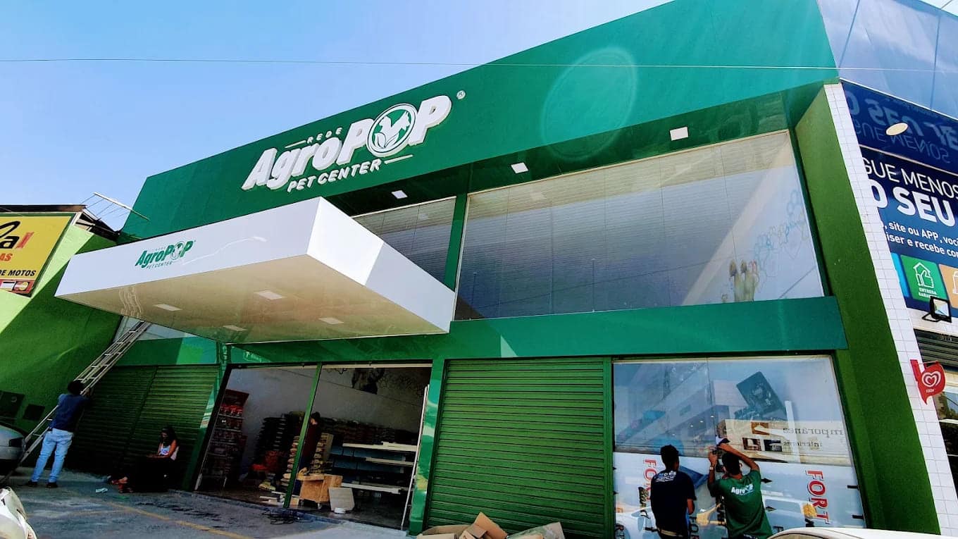 Fachada da AgroPOP Pet Center revestida em ACM verde, com letra caixa iluminada e marquise branca em balanço