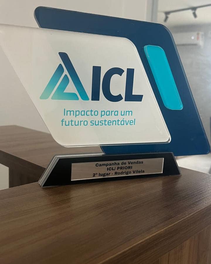Troféu em acrílico da ICL com a marca impressa e placa metálica gravada na base