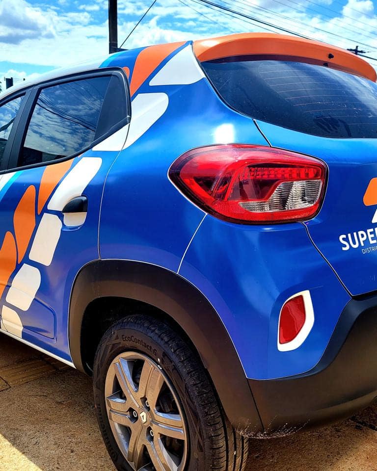Carro compacto da Supermédica envelopado em azul com grafismos laranja, teto e retrovisores em laranja