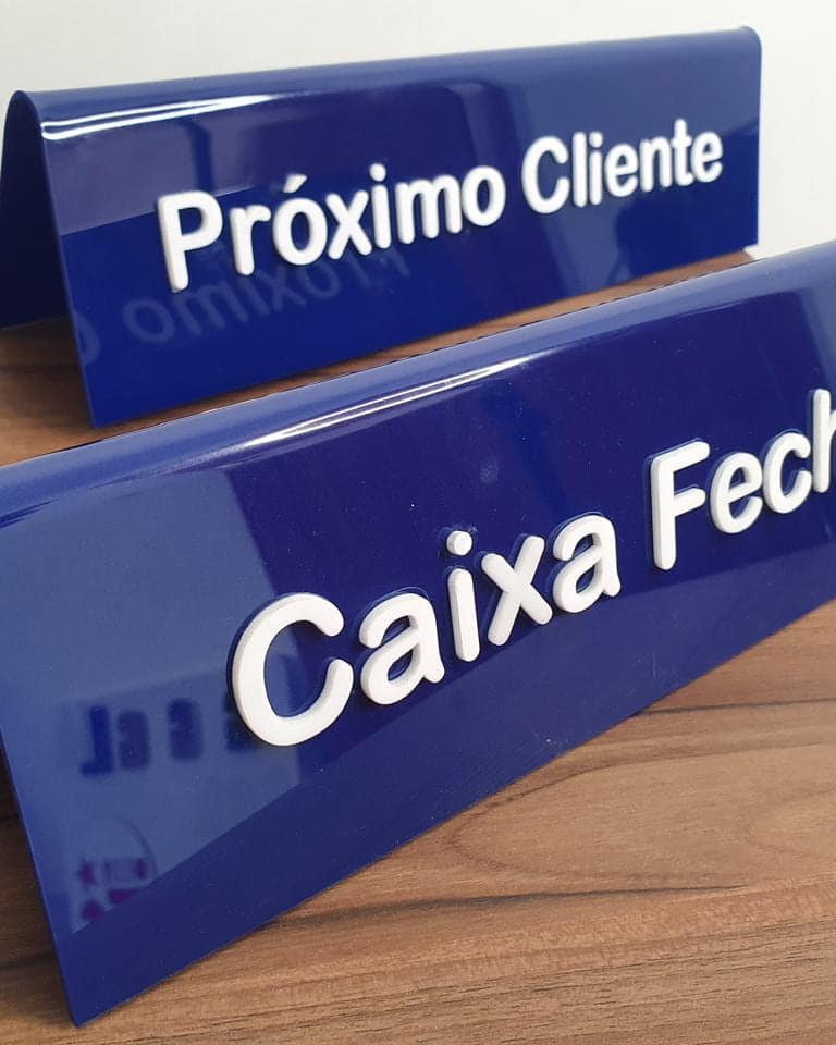 Placas de mesa em acrílico azul dobrado, com os avisos Próximo Cliente e Caixa Fechado em letras brancas