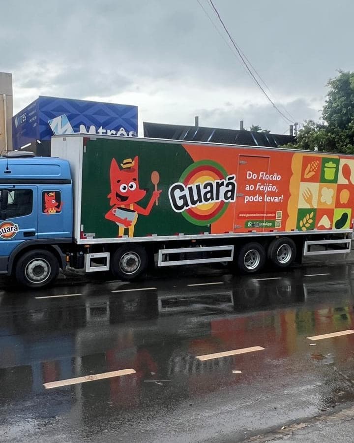 Carreta da Guará Alimentos com o baú envelopado em vinil, mascote e assinatura da marca ocupando toda a lateral