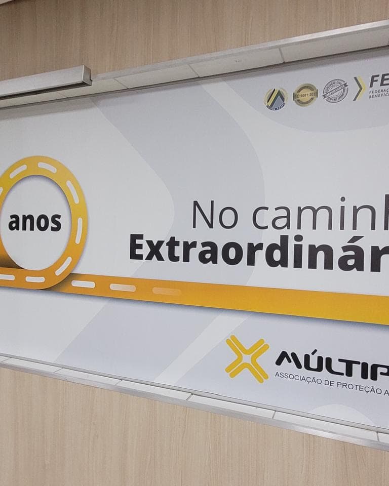 Vidro interno da Múltipla com adesivo impresso comemorativo dos dez anos, em branco, amarelo e cinza