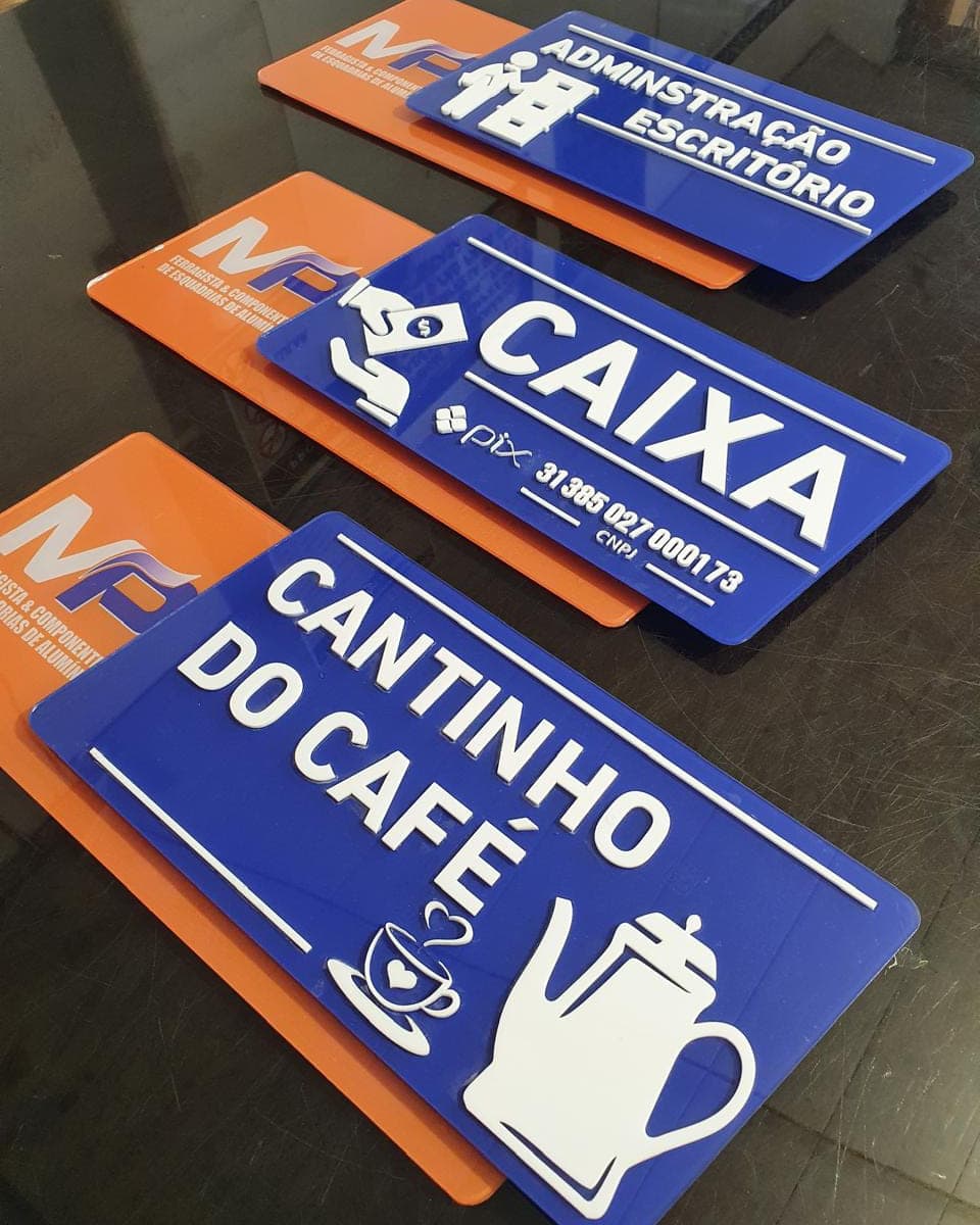 Placas internas de identificação em azul e laranja, com pictograma e o nome de cada ambiente: caixa, administração e cantinho do café