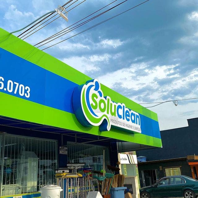 Testeira luminosa da Soluclean em faixa verde e azul com marca em volume destacado