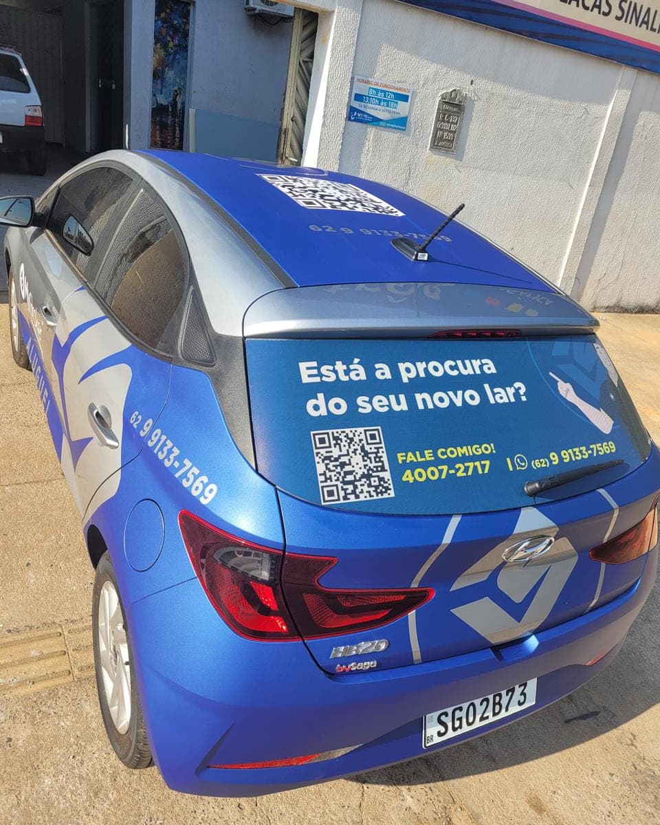 Hatch envelopado em vinil azul, com chamada de campanha, QR code e telefone aplicados no vidro traseiro