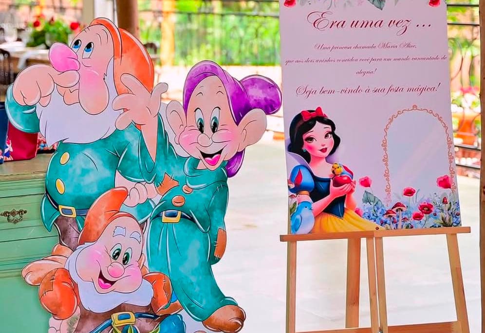 Display recortado com personagens e placa de boas-vindas em cavalete, montados em festa de tema infantil