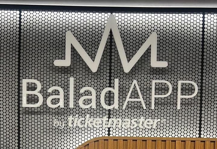 Letreiro do BaladAPP em acrílico sobre painel metálico perfurado, com iluminação por trás