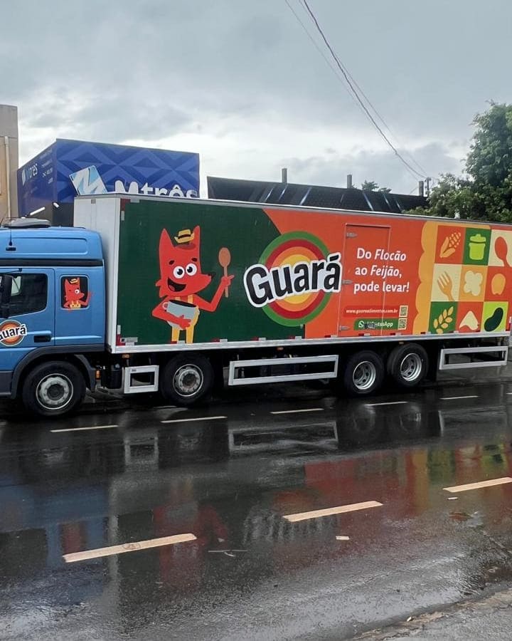 Carreta da Guará Alimentos com o baú envelopado em vinil, mascote e assinatura da marca ocupando toda a lateral