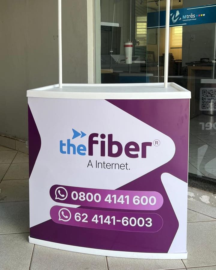 Balcão de ponto de venda da The Fiber em roxo e branco, com testeira suspensa por hastes