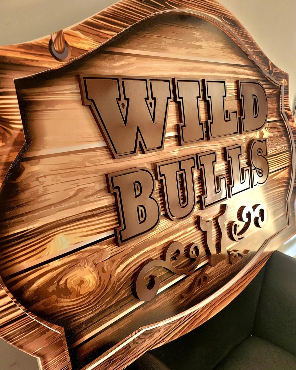 Placa da Wild Bulls em PVC expandido com impressão de madeira e letras recortadas aplicadas em relevo